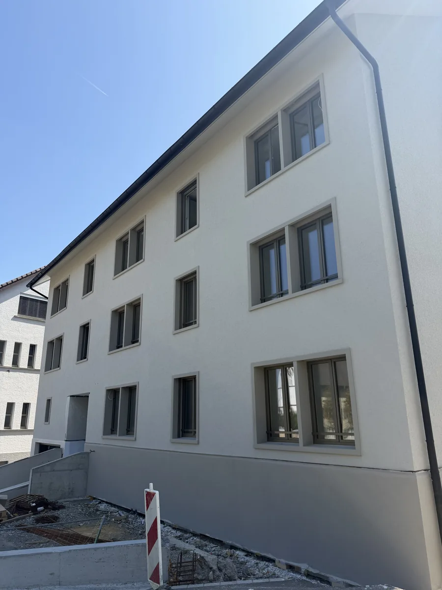 Weisse Putzfassade mit Fensteranschlüssen