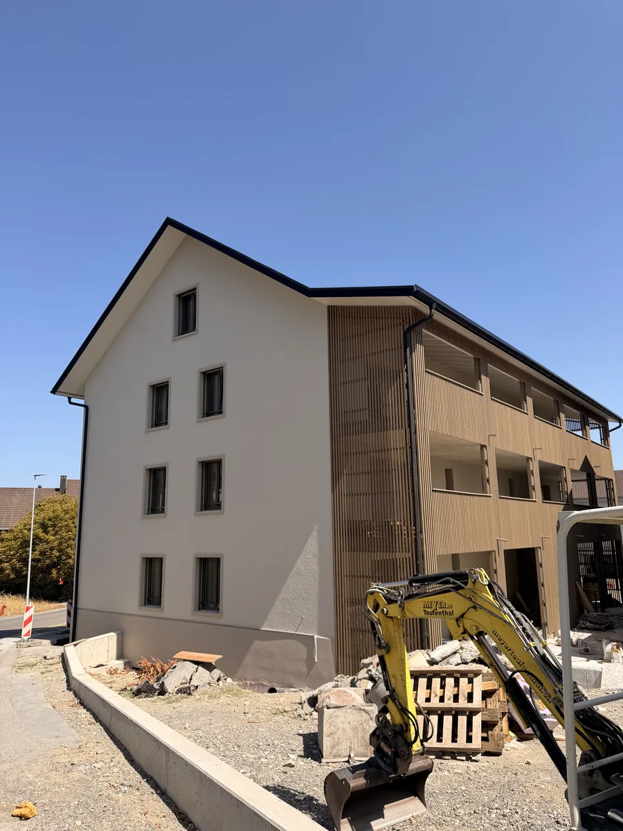 Verputzte Hausfassade mit Holzbalkonen