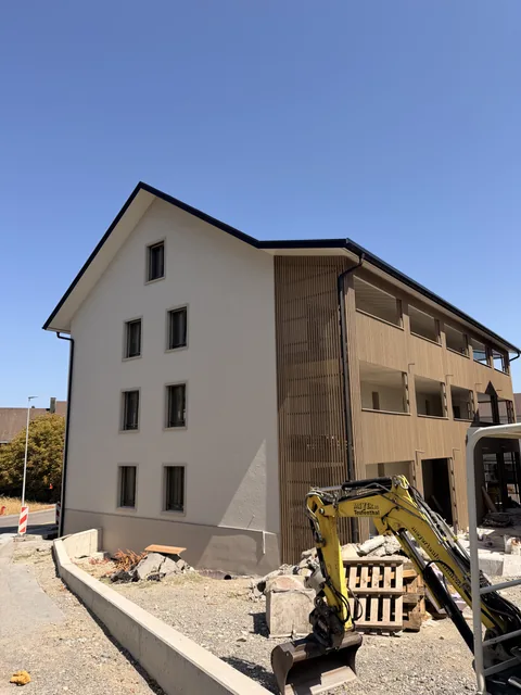 Verputzte Hausfassade mit Holzbalkonen